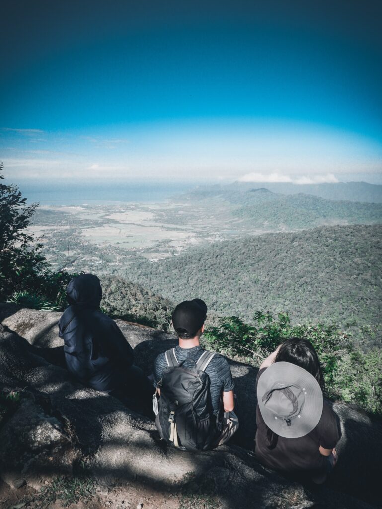 3 people sat looking at the view from Gunung Raya